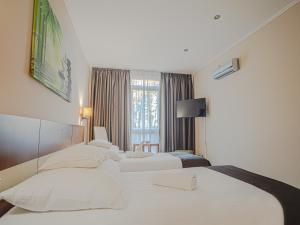 a hotel room with two beds and a window at Holiday Beach Budapest Wellness Hotel with Sauna Park in Budapest