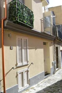 a building with a balcony and a door at B&B O Casteddu in Monforte San Giorgio