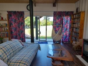 a living room with a couch and a hammock at Butterfly House in The Crags