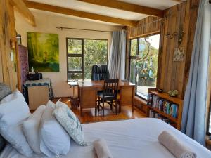 a bedroom with a bed and a desk and a table at Butterfly House in The Crags