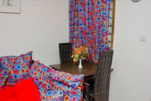 Un comedor con una mesa y una cortina roja y azul. en African themed one bedroom, en Diani Beach