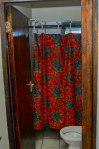 y baño con cortina de ducha y aseo. en African themed one bedroom, en Diani Beach