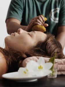 Una donna che si fa tagliare i capelli con una banana di Palm Garden Ayurveda Resort ad Ahangama