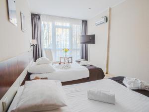 a hotel room with two beds and a window at Holiday Beach Budapest Wellness Hotel with Sauna Park in Budapest