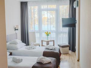 a hotel room with two beds and a window at Holiday Beach Budapest Wellness Hotel with Sauna Park in Budapest