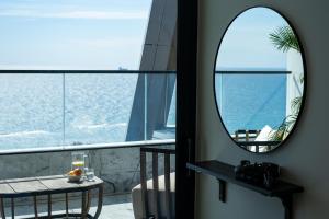 a mirror in a room with a table and a balcony at The Icon Limassol in Limassol +27 photos