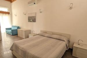 a bedroom with a bed and a blue chair at Villetta con Piscina su Terrazza vista mare in Sanremo