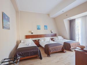 a hotel room with two beds and a window at Holiday Beach Budapest Wellness Hotel with Sauna Park in Budapest