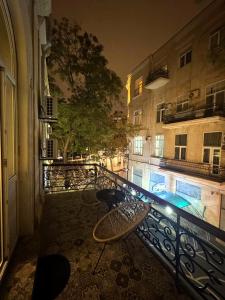 a balcony with a table and chairs and a building at Zimmer Boutique Hotel in Baku