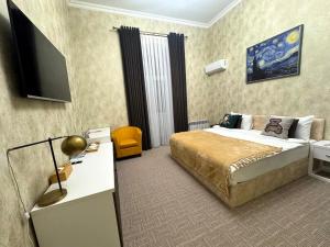 a hotel room with a bed and a flat screen tv at Zimmer Boutique Hotel in Baku