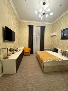 a bedroom with a bed and a desk and a television at Zimmer Boutique Hotel in Baku