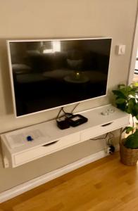 a flat screen tv sitting on top of a white table at Lille Øvregate in Bergen