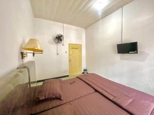 a bedroom with a bed and a television in it at Nan kanduang Homestay in Bukittinggi +9 photos