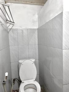 a bathroom with a white toilet in a room at Nan kanduang Homestay in Bukittinggi