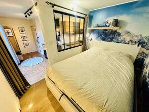 une chambre avec un grand lit dans une pièce dans l'établissement Les 3 Vallées, Appartement Montagnard avec Spa et Piscine, à Orelle 42 autres photos