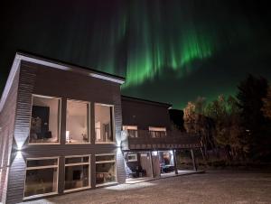 een appartementencomplex met het noorderlicht in de lucht bij The House of Aurora I in Tromsø