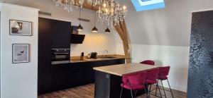 a kitchen with a table and some red bar stools at La suite Baroque jacuzzi au cœur du château de Boissettes in Boissettes