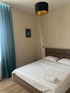 a bedroom with a bed and a blue curtain at temuka in Samgori