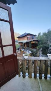 una porta aperta e un tavolo in legno con una casa sullo sfondo di De hemp homestay a Lao Cai