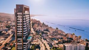 a city with a tall building next to the ocean at The Icon Limassol in Limassol