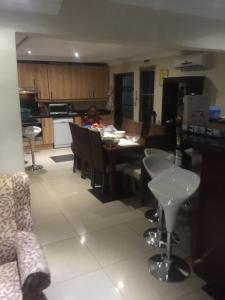 a kitchen and living room with a table and chairs at The Raps Guesthouse in Meadowlands