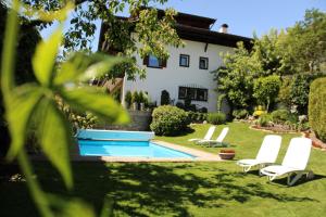 a yard with two chairs and a swimming pool at Ferienwohnungen Innerhofer in Rifiano