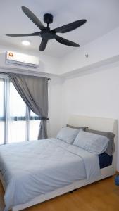 Un dormitorio con una cama con ventilador de techo. en Mayabay Gamuda Cove SplashMania Suite, en Banting