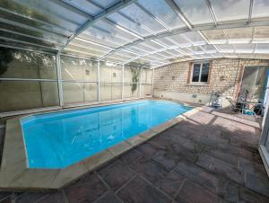 an indoor swimming pool with a roof over it at Villa Evasion in Louviers