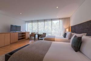 a hotel room with two beds and a flat screen tv at Faranda Collection Bogota, a member of Radisson Individuals in Bogotá +137 photos