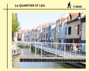 a bridge over a river in a city with buildings at Au Pied de la gare et centre ville - 2 chambres - spacieux in Amiens