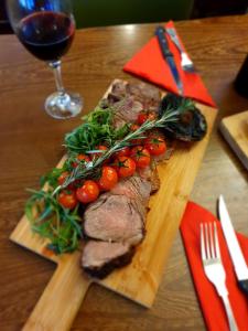 a steak on a wooden cutting board with a glass of wine at The Hind Hotel in Wellingborough