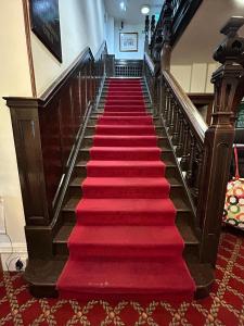 a red carpeted staircase in a building with a red carpet at The Hind Hotel in Wellingborough