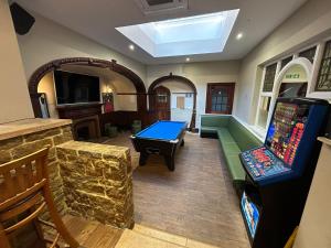 a room with a pool table and a video game at The Hind Hotel in Wellingborough