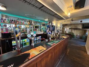 a bar in a pub with a lot of alcohol at The Hind Hotel in Wellingborough