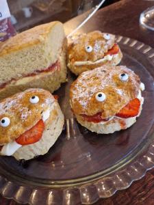 a plate with three sandwiches with faces on them at The Hind Hotel in Wellingborough