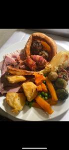 a plate of food with meat and vegetables on a table at The Hind Hotel in Wellingborough