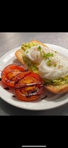 a plate with an egg and tomatoes on a sandwich at The Hind Hotel in Wellingborough