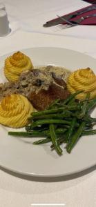a white plate of food with meat and green beans at The Hind Hotel in Wellingborough