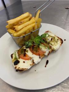 a piece of food on a plate with a basket of fries at The Hind Hotel in Wellingborough