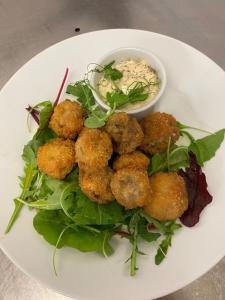 a plate of food with meatballs on top of a salad at The Hind Hotel in Wellingborough