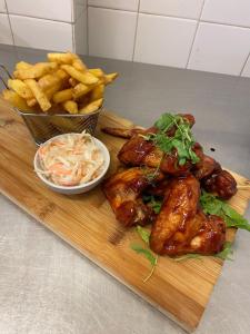a cutting board with chicken wings and french fries at The Hind Hotel in Wellingborough