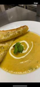 a plate of food with a soup with a swirl at The Hind Hotel in Wellingborough
