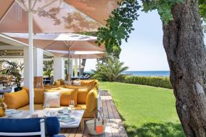 a patio with a table and chairs and an umbrella at ME Ibiza - The Leading Hotels of the World in Santa Eularia des Riu