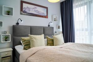 a bedroom with a large bed and a window at Horyzont by Baltic Home in Międzyzdroje