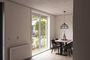 a dining room with a table and a window at Tiny House 'Veluwehuisje' in Voorthuizen