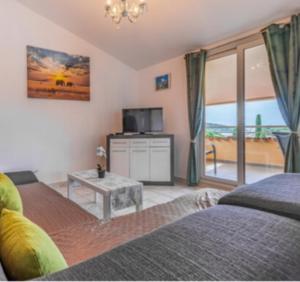 a living room with a bed and a tv and a table at Regina 1 in Banjole