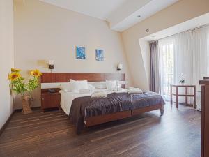 a bedroom with a large bed and a large window at Holiday Beach Budapest Wellness Hotel with Sauna Park in Budapest