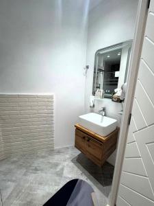 a white bathroom with a sink and a mirror at Zimmer Boutique Hotel in Baku