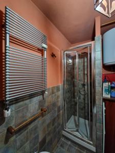 ein Bad mit einer Dusche und einer Glasduschkabine in der Unterkunft APPARTAMENTO SAUZE D'OULX in Sauze dʼOulx