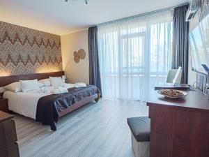 a hotel room with a bed and a desk with a computer at Holiday Beach Budapest Wellness Hotel with Sauna Park in Budapest